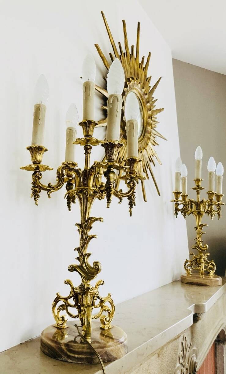Massive gilded bronze chandeliers from the mid-20th century with marble bases.