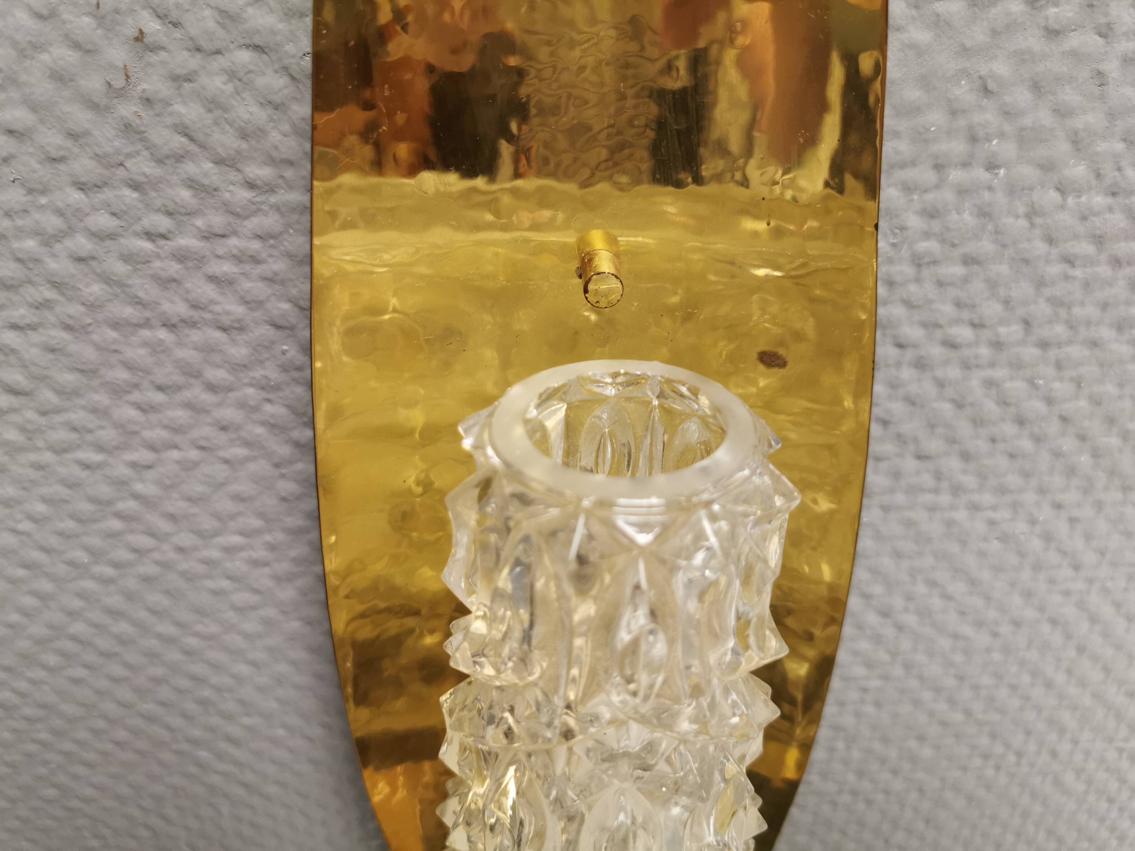 Older wall lamp in brass with hard pressed glass shade.