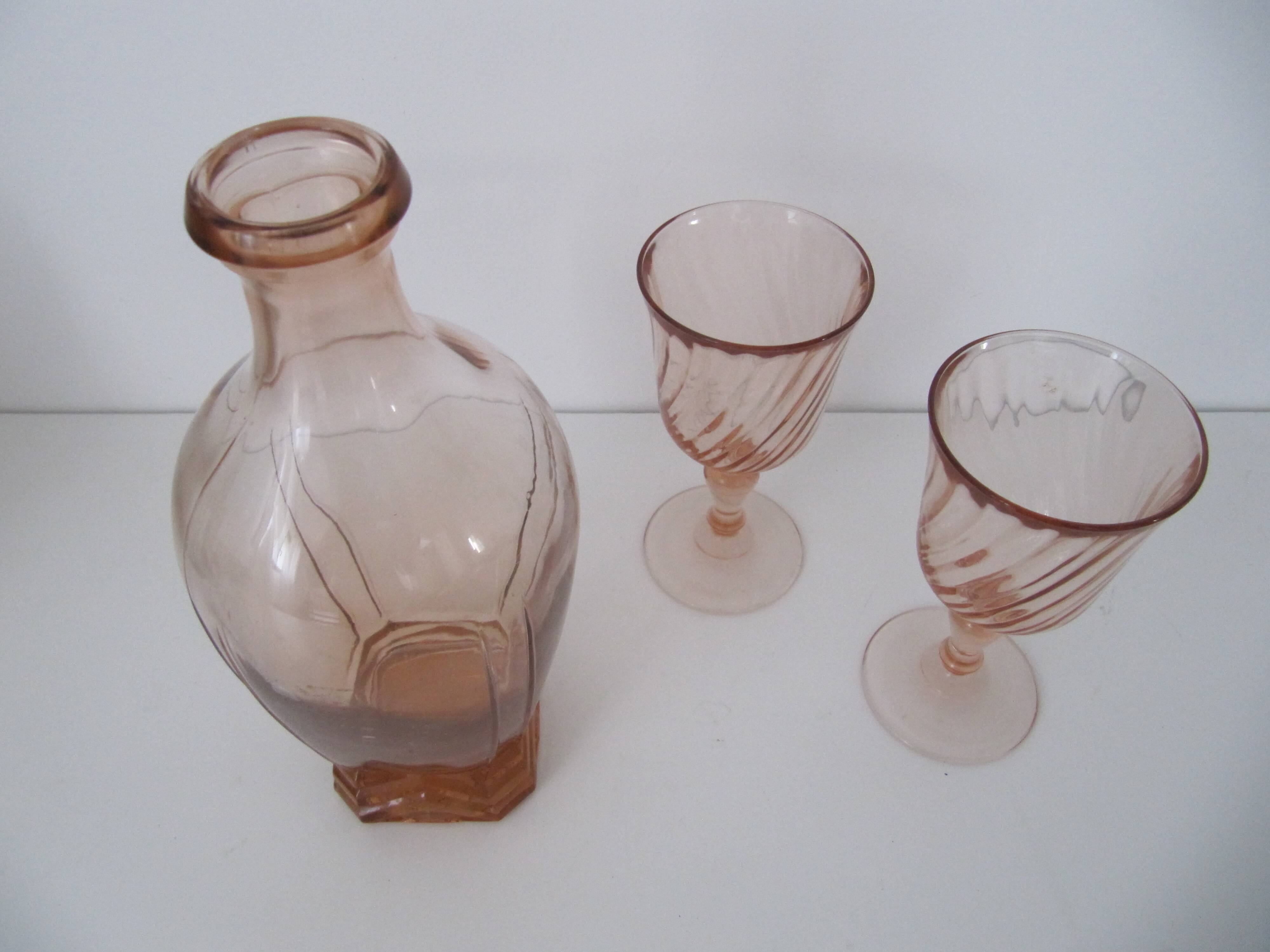 Old bottle in pink glass and 2 wine glasses