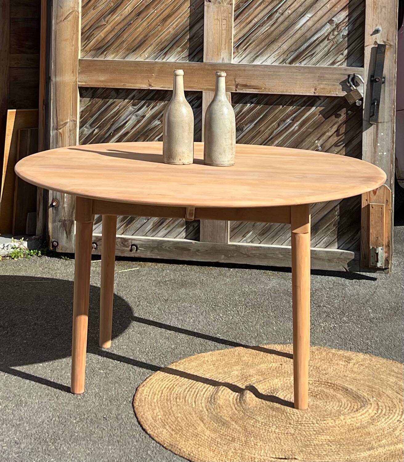 Large round family table with 2 extensions in solid raw wood.