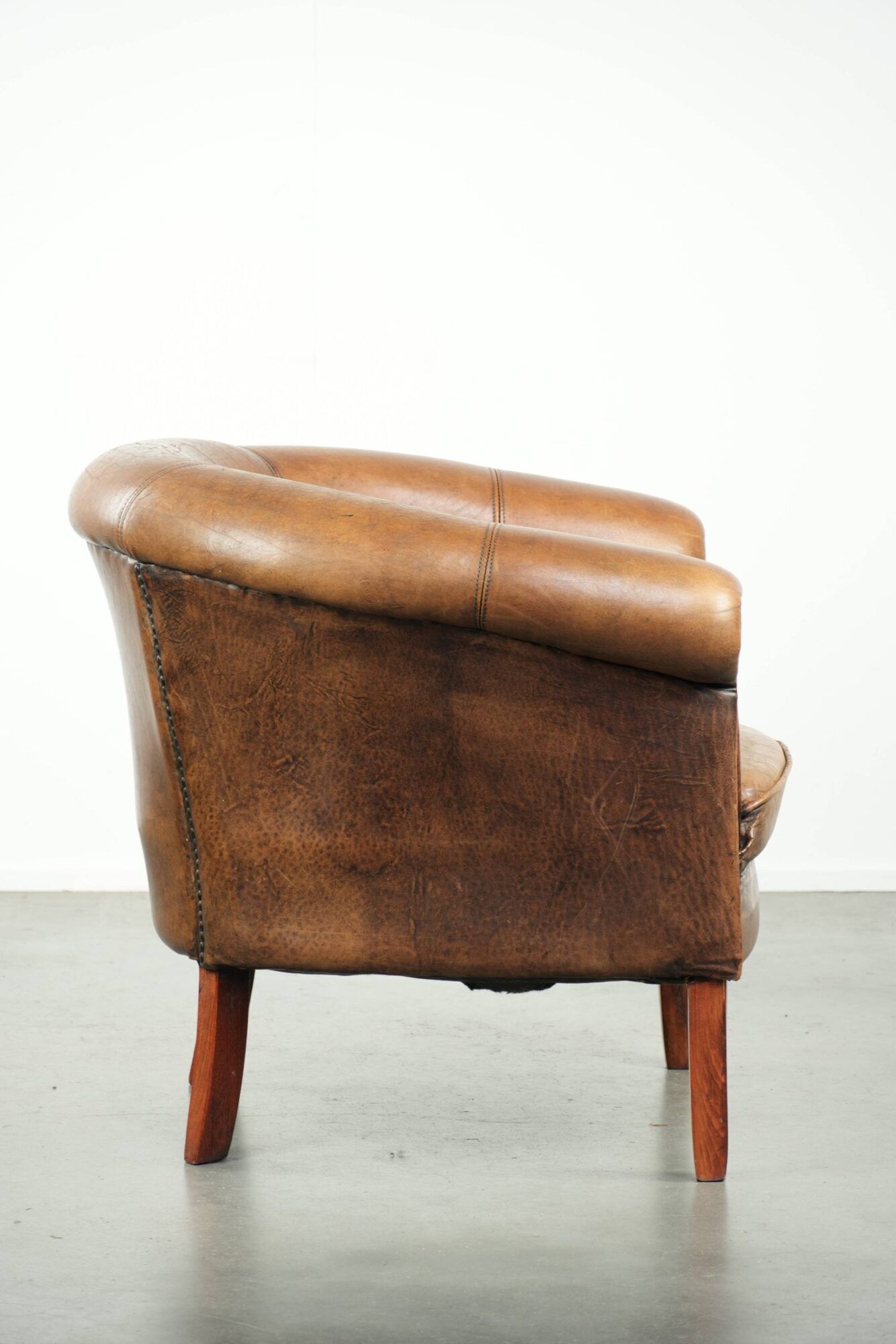 Sheepskin club armchair in a brown colour finished with decorative nails