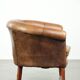 Sheepskin club armchair in a brown colour finished with decorative nails