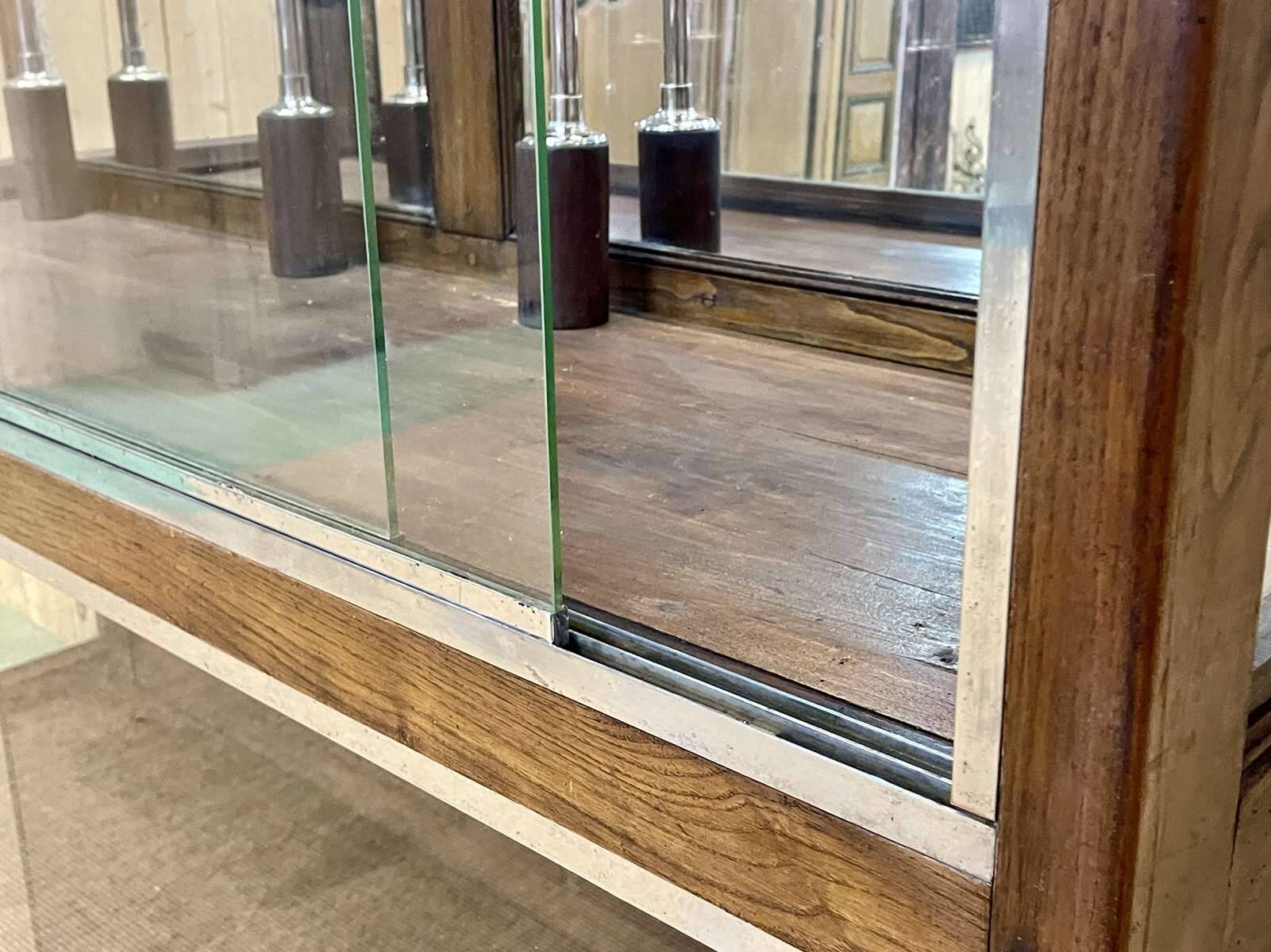 Early 20th-century shop display cabinet in oak with sliding doors.