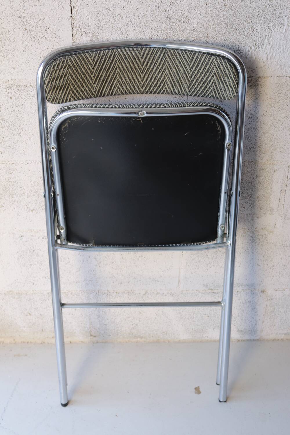 Vintage folding chair in chrome metal and chevron fabric.