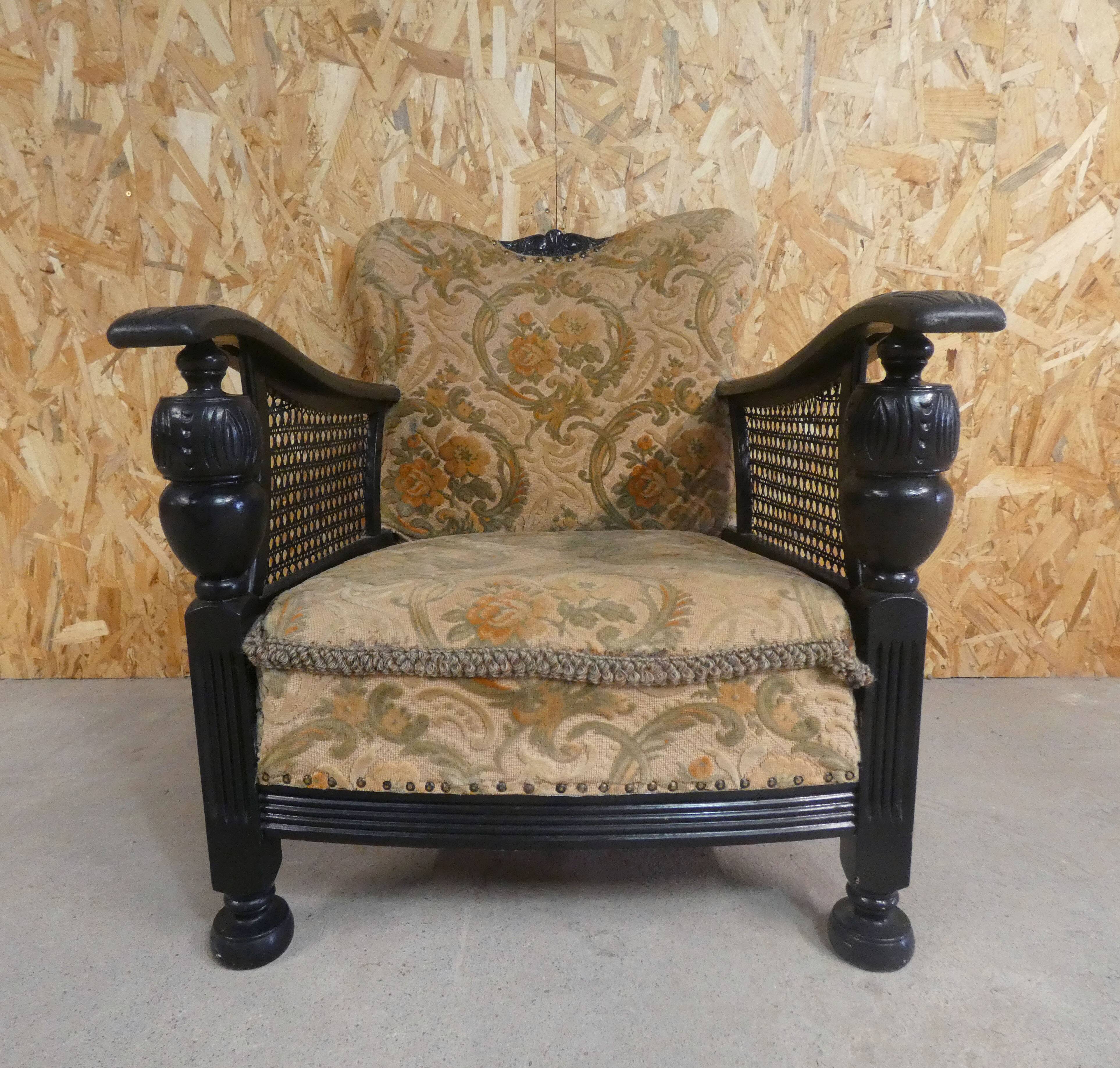 Old armchair upholstered in velvet, carved and caned wood