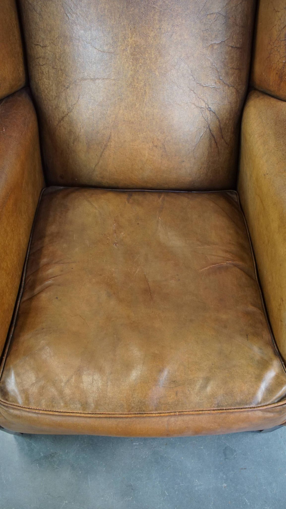 Patinated sheep leather wingback armchair