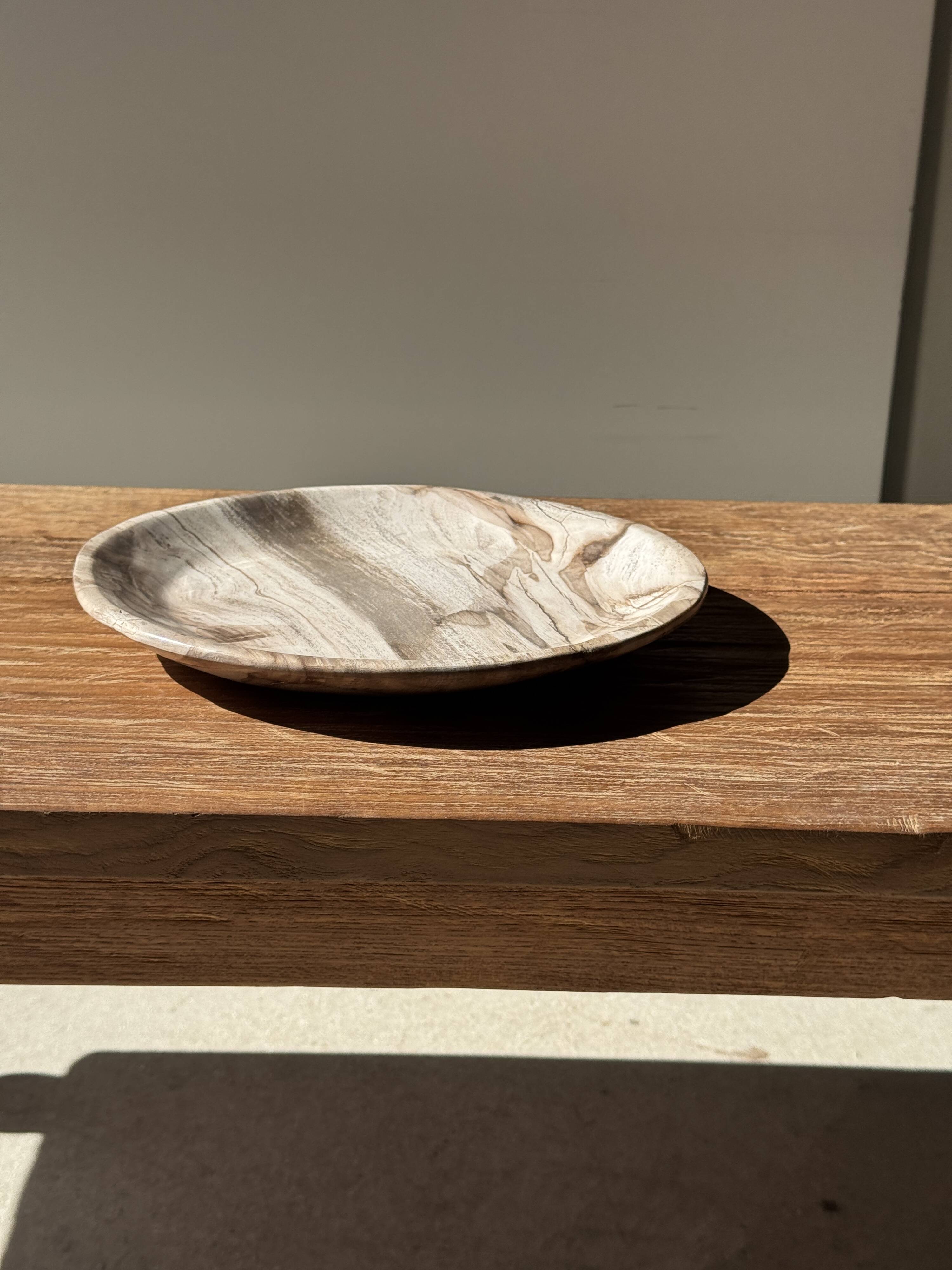Tray, circular dish or plate made of white striped grey petrified wood.