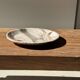 Tray, circular dish or plate made of white striped grey petrified wood.