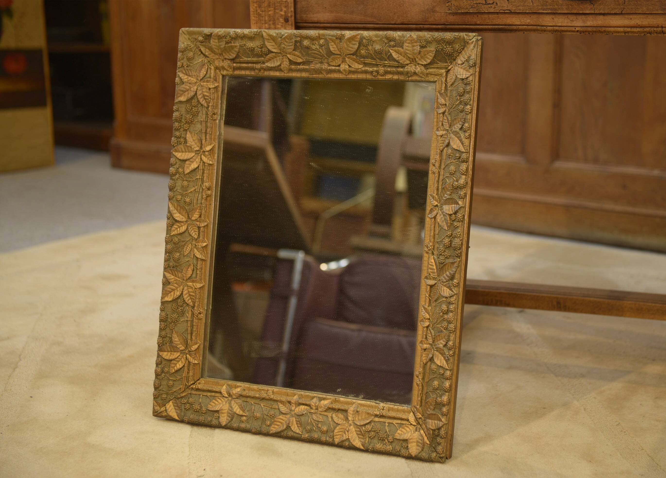 19th-century mirror in wood and stucco with floral decoration.