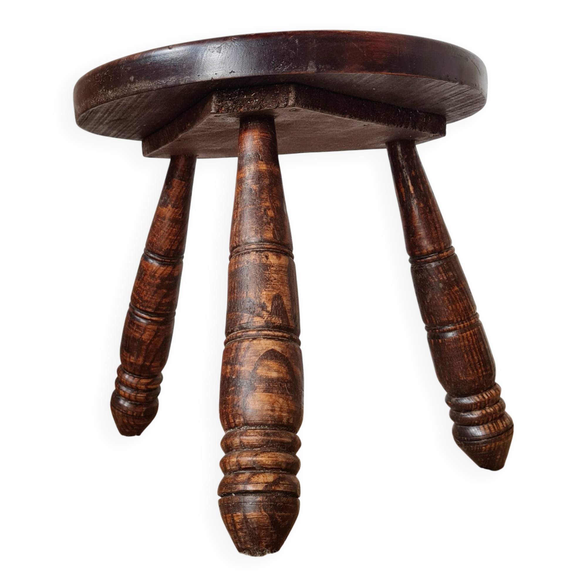 Small brutalist tripod stool made of turned wood.
