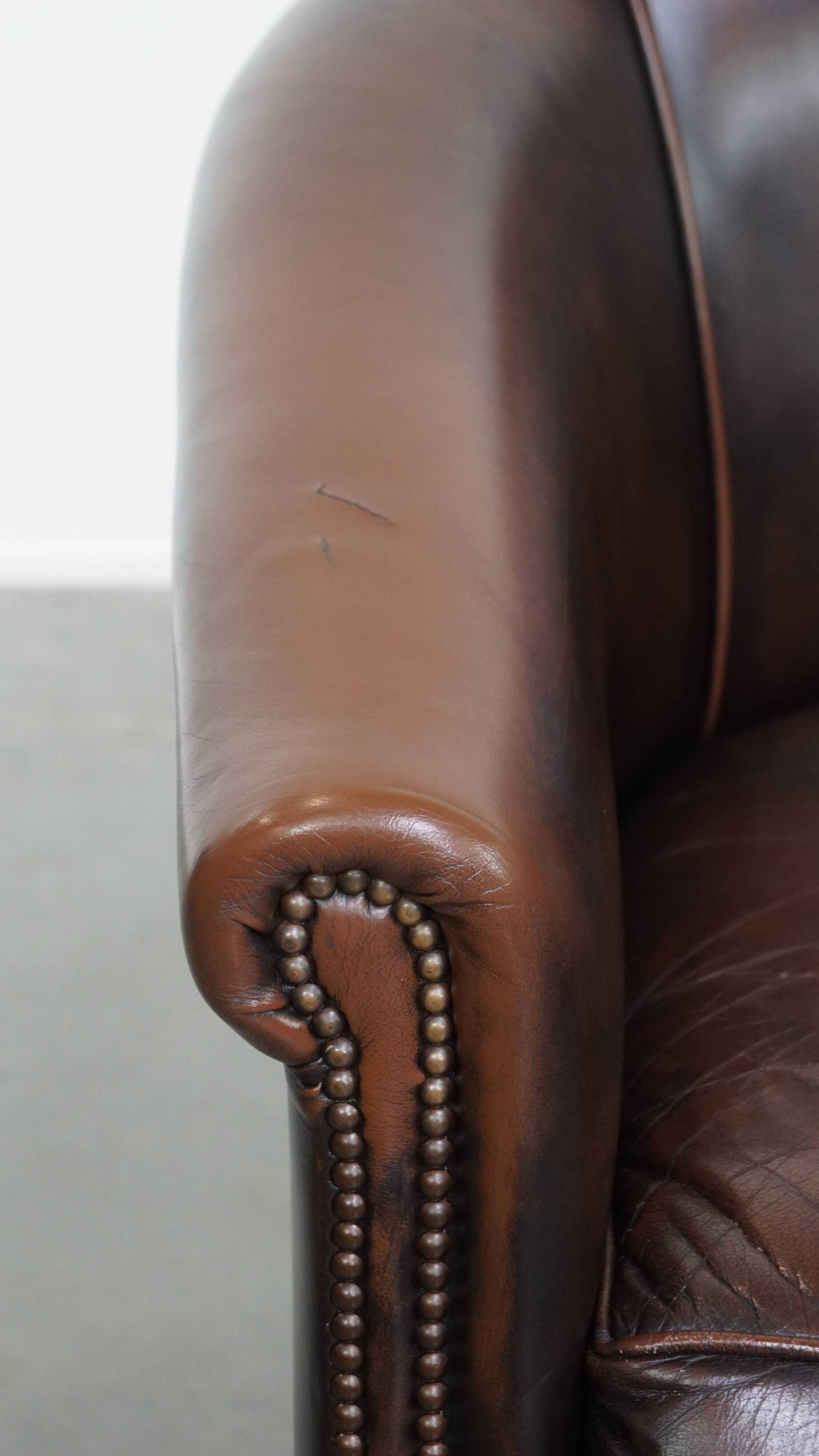 Fauteuil club de couleur foncée en cuir de vachette