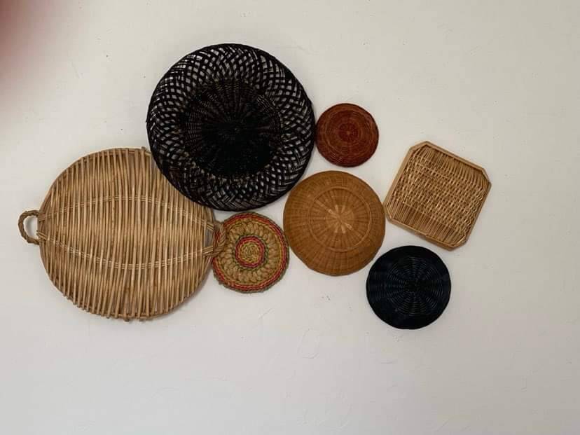 Composition murale de corbeilles et plateaux en osier.