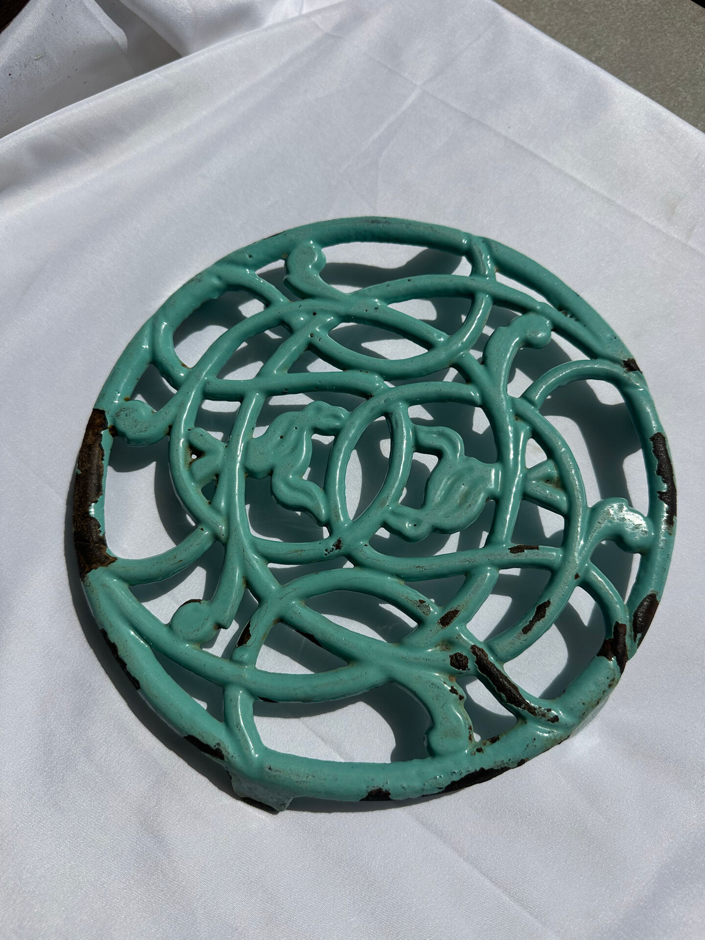 Enamelled cast iron trivet in blue with wrought iron decoration.