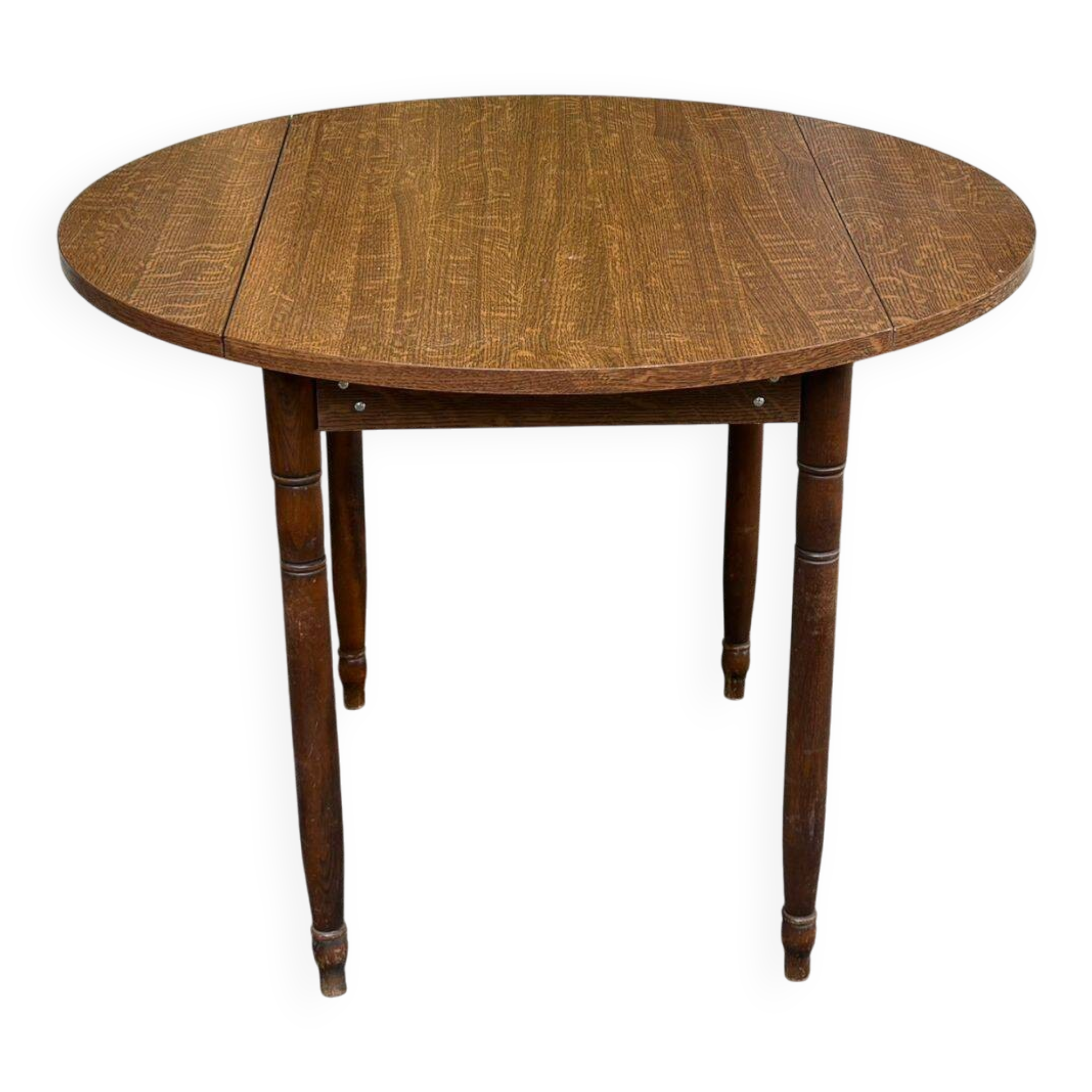Round kitchen table with extendable leaves in dark wood.