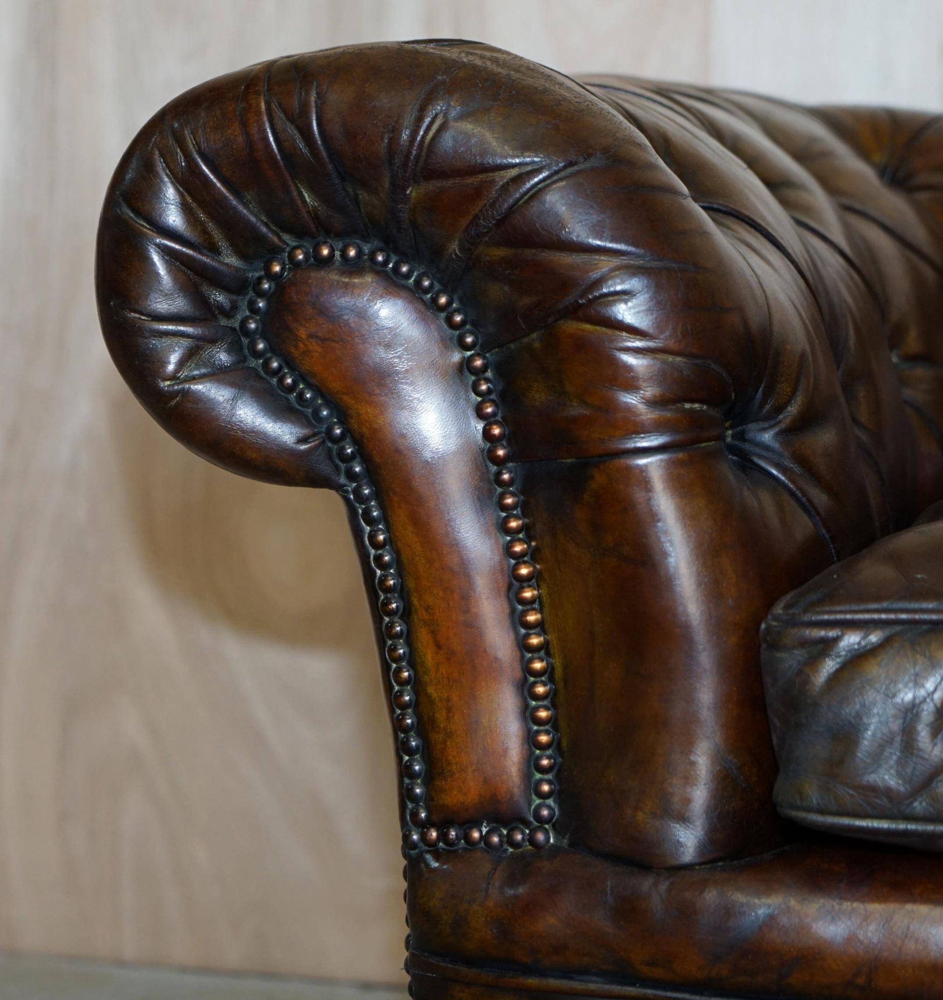 Victorian Chesterfield leather upholstered canapé with feather cushions.