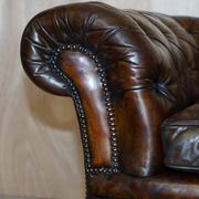 Victorian Chesterfield leather upholstered canapé with feather cushions.