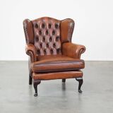 Very beautiful, stately, cowhide Chesterfield wing chair with elegant legs in a nice brown color