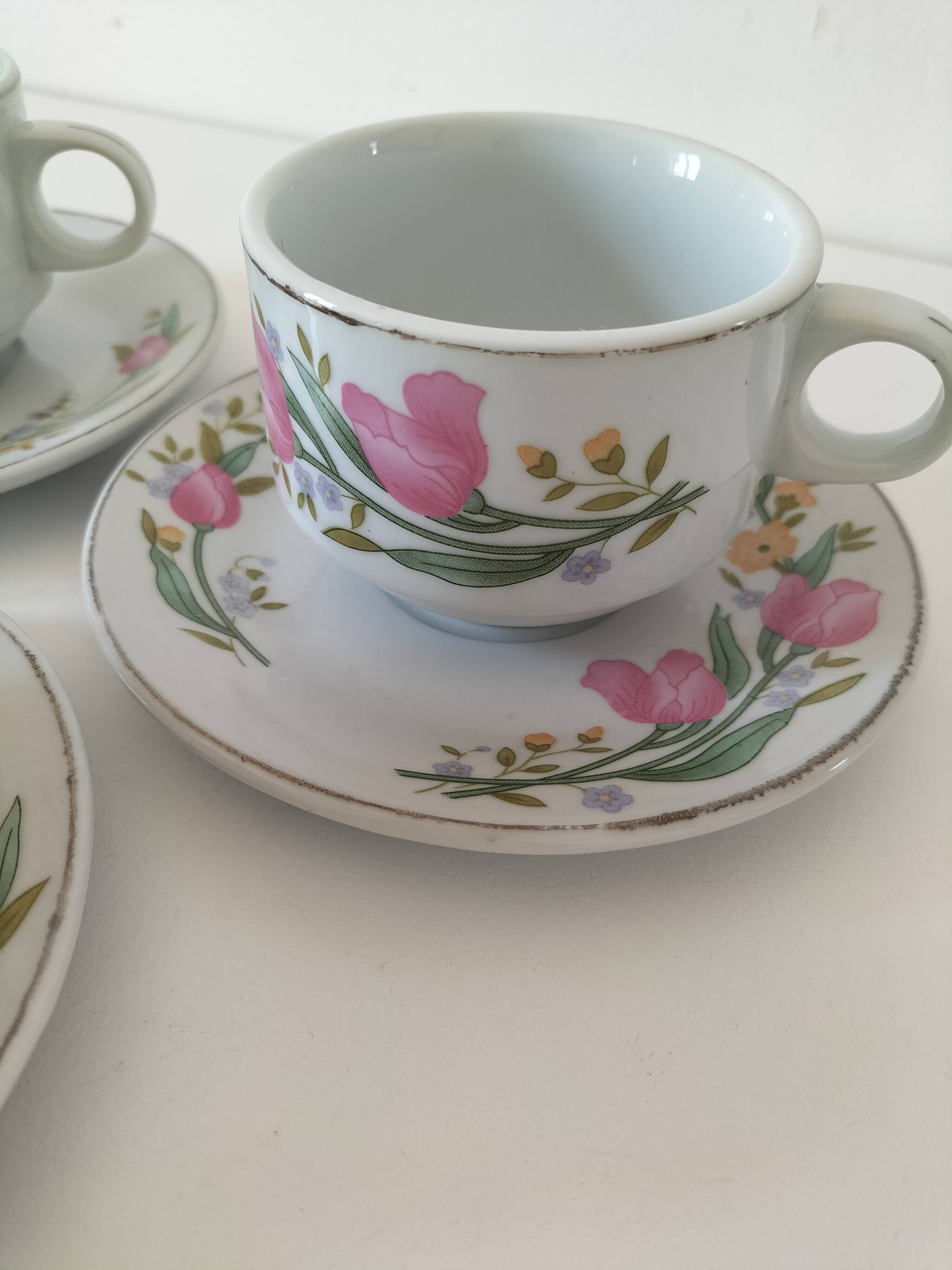 Trio of floral porcelain cups and saucers