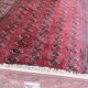 Large red Bokhara-style oriental carpet 300x200 cm with gul patterns.