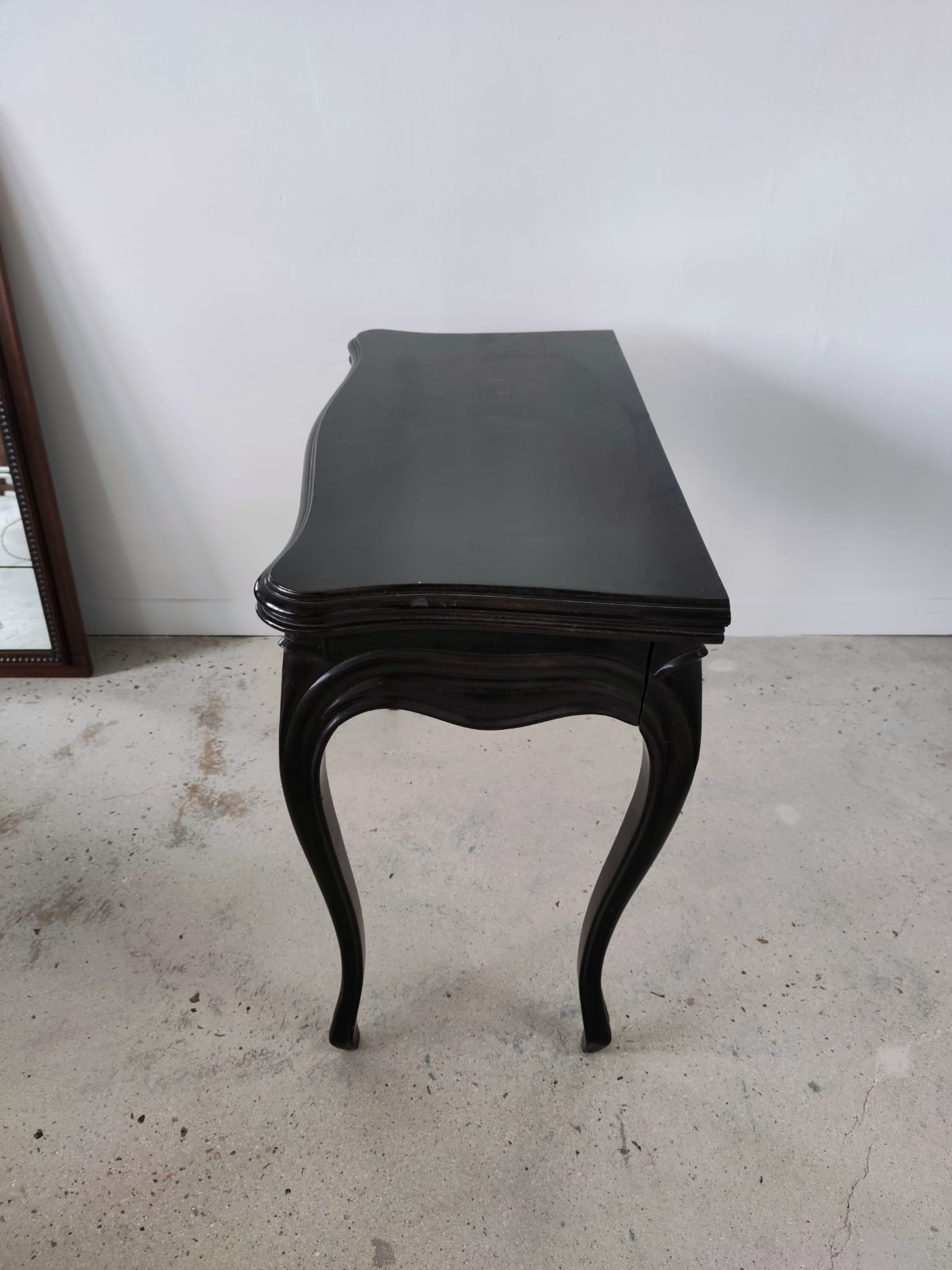 Molded blackened wooden play table, arched legs, green felt