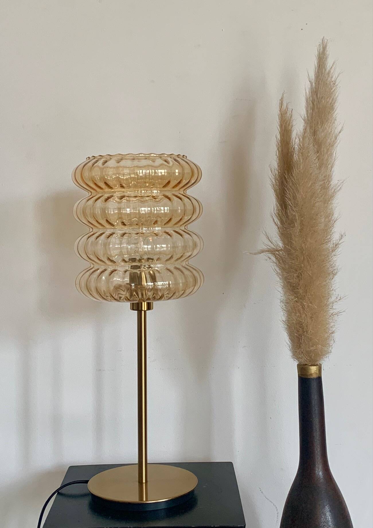 Table lamp with an old vintage golden striped globe and a golden foot