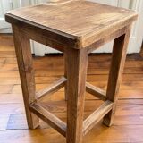 Brutalist stool in raw wood with a weathered effect.