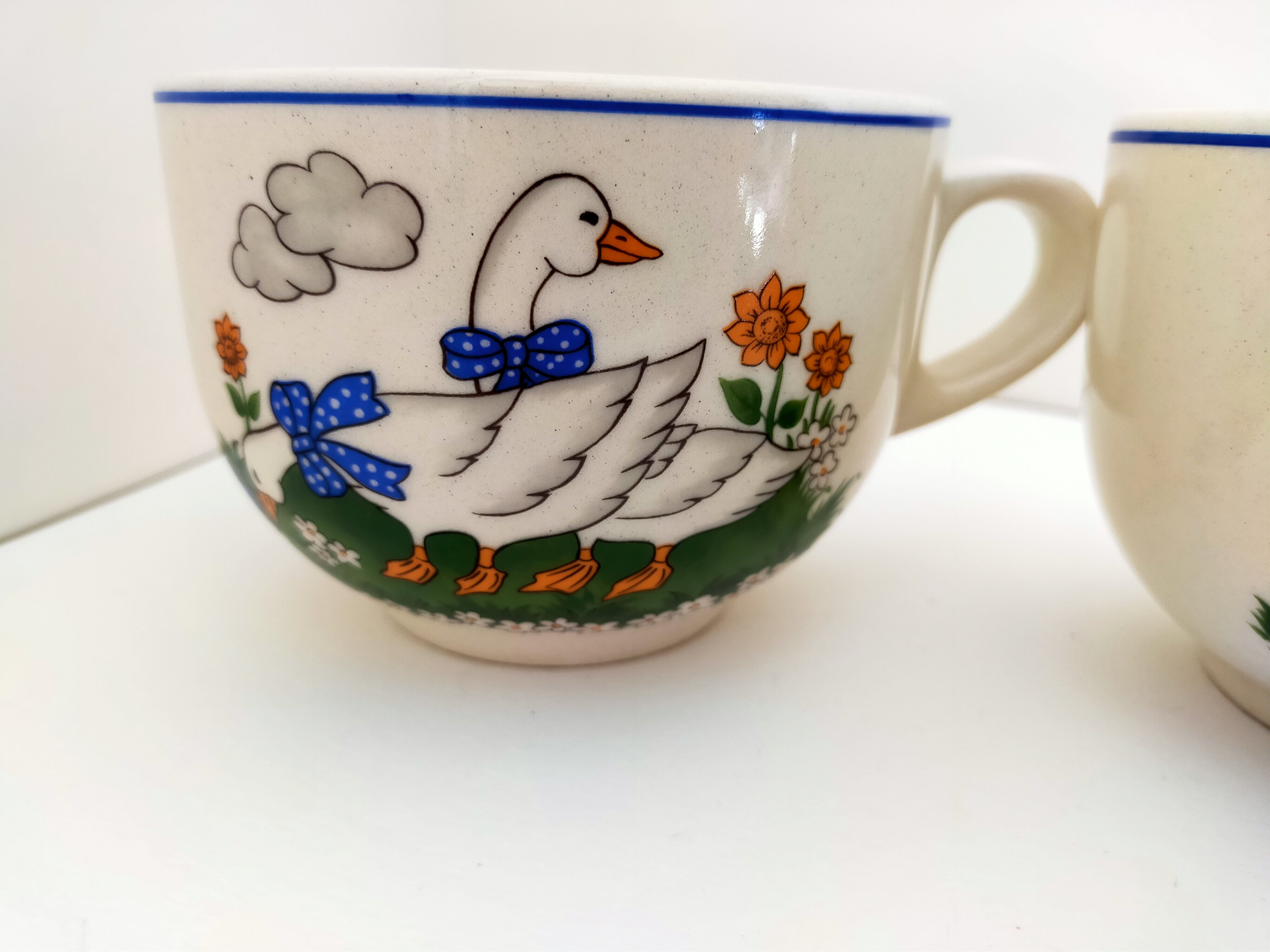 Paire de bols blancs avec anse vintage faïence art déco décor animalier:oies aux rubans bleus