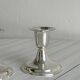 A pair of small silver-white metal candle holders.