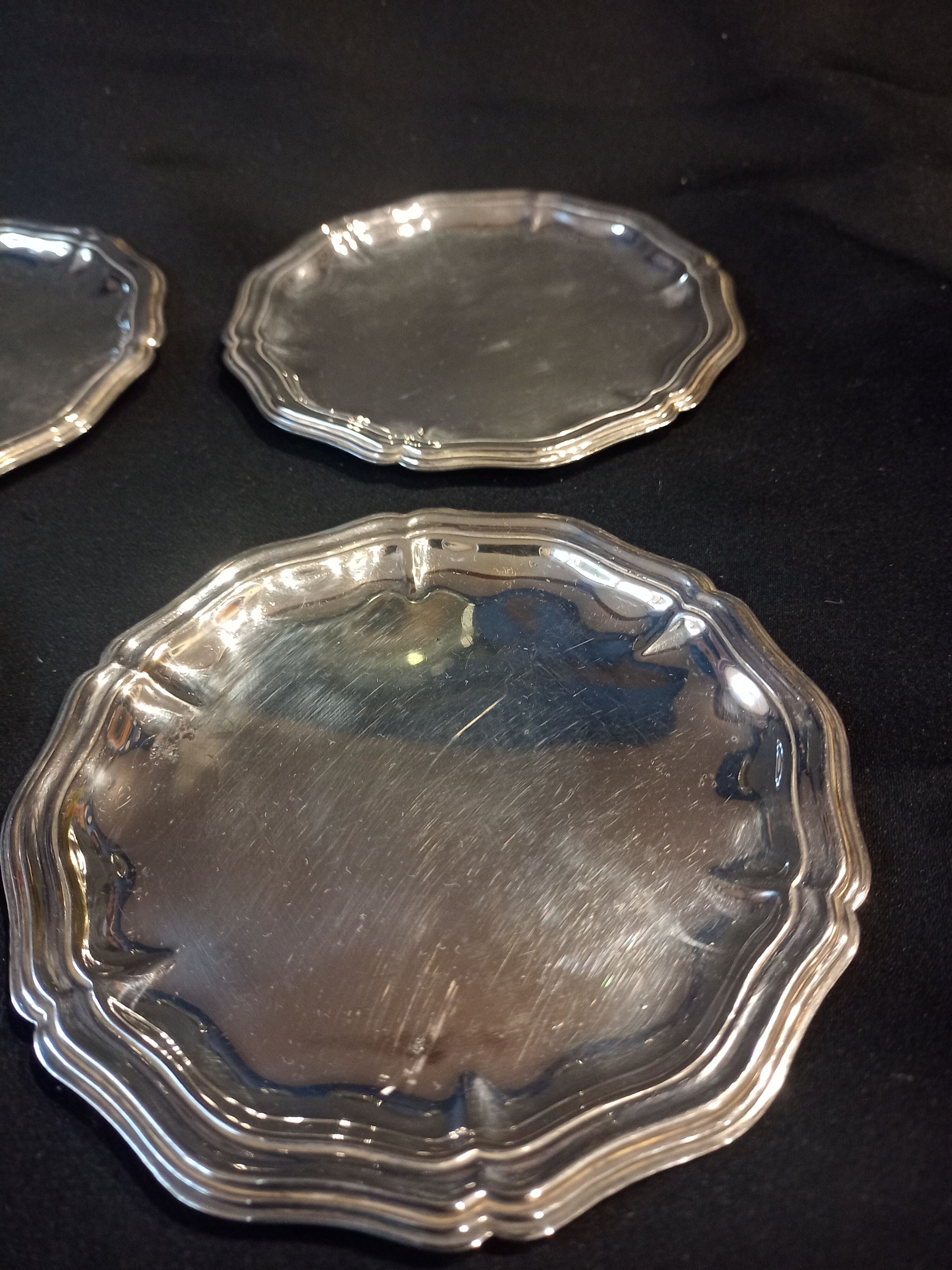 Four silver metal bottle bottoms