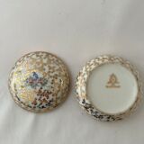 White and golden pill box with a blue bird