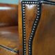 Art deco armchair in sheepskin with black piping and decorative nails