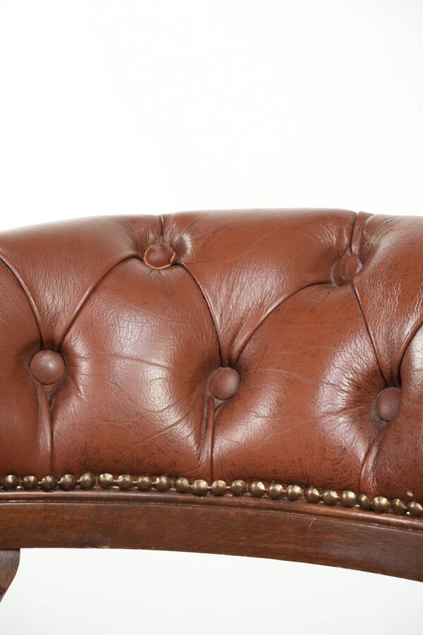 Chaise de bureau chesterfield en cuir de vachette pivotante de style anglais de couleur marron.