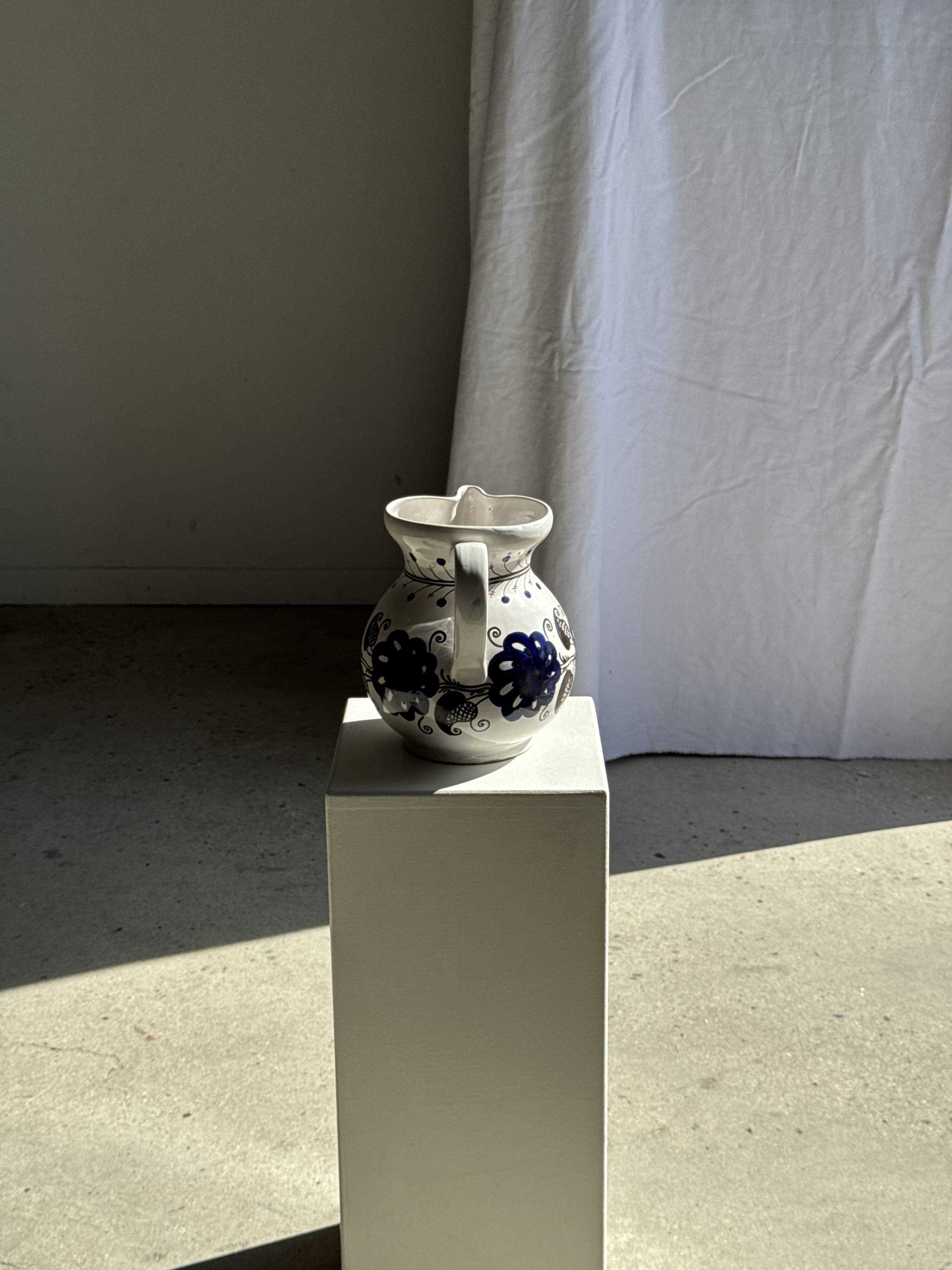 Very large vintage ceramic carafe in white glazed with blue floral decoration.