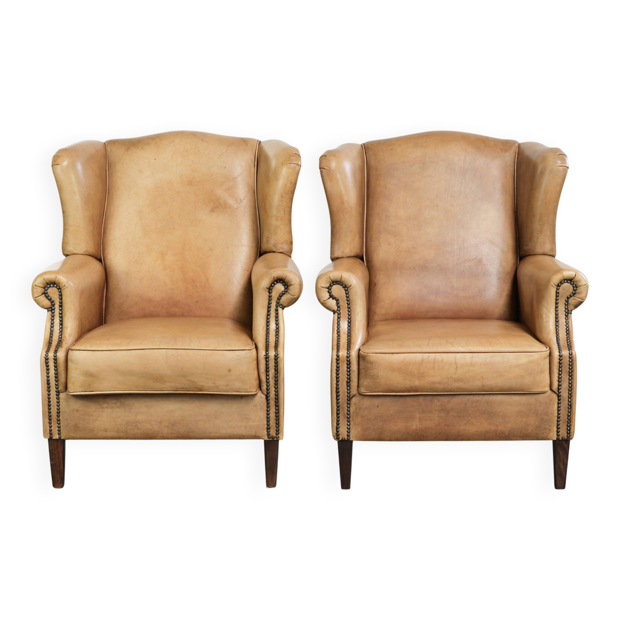 Set of two light cowhide wingback armchairs with a timeless English look