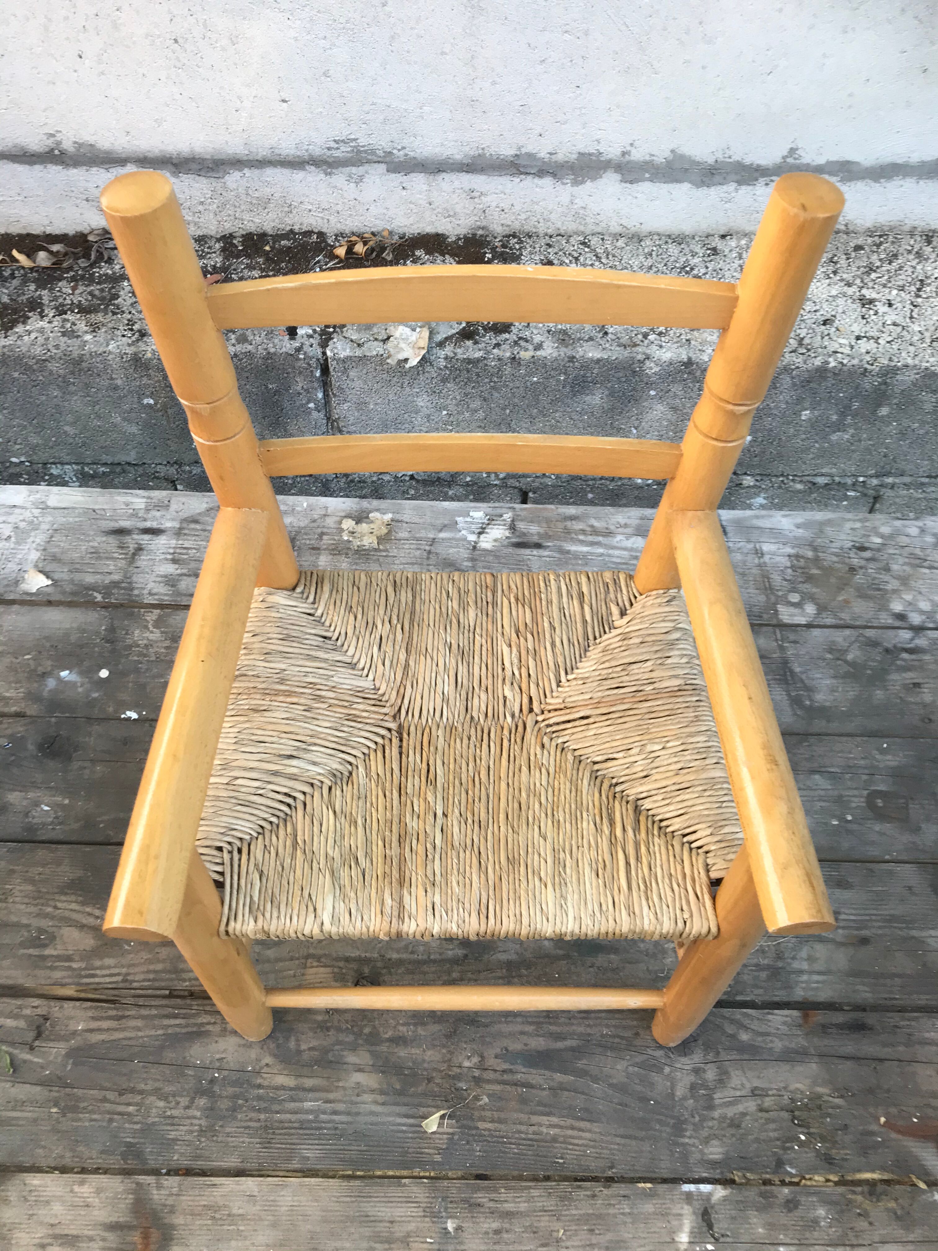 Old wooden children's armchair and vintage woven straw seat