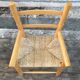 Old wooden children's armchair and vintage woven straw seat