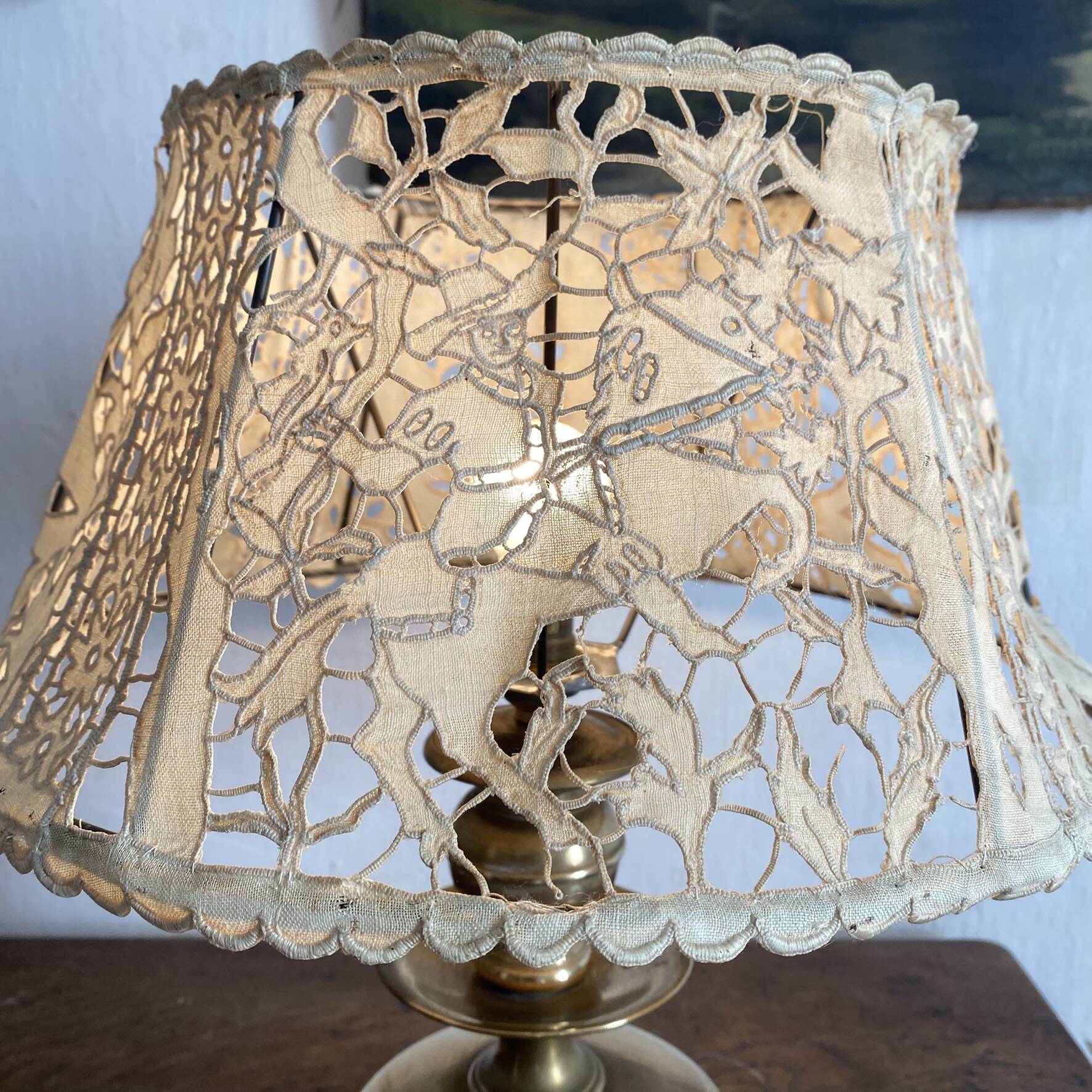 Antique brass lamp with embroidered openwork shade.