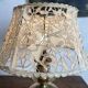 Antique brass lamp with embroidered openwork shade.