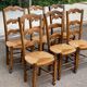 6 solid wood chairs with straw seats and butterfly carved backs.