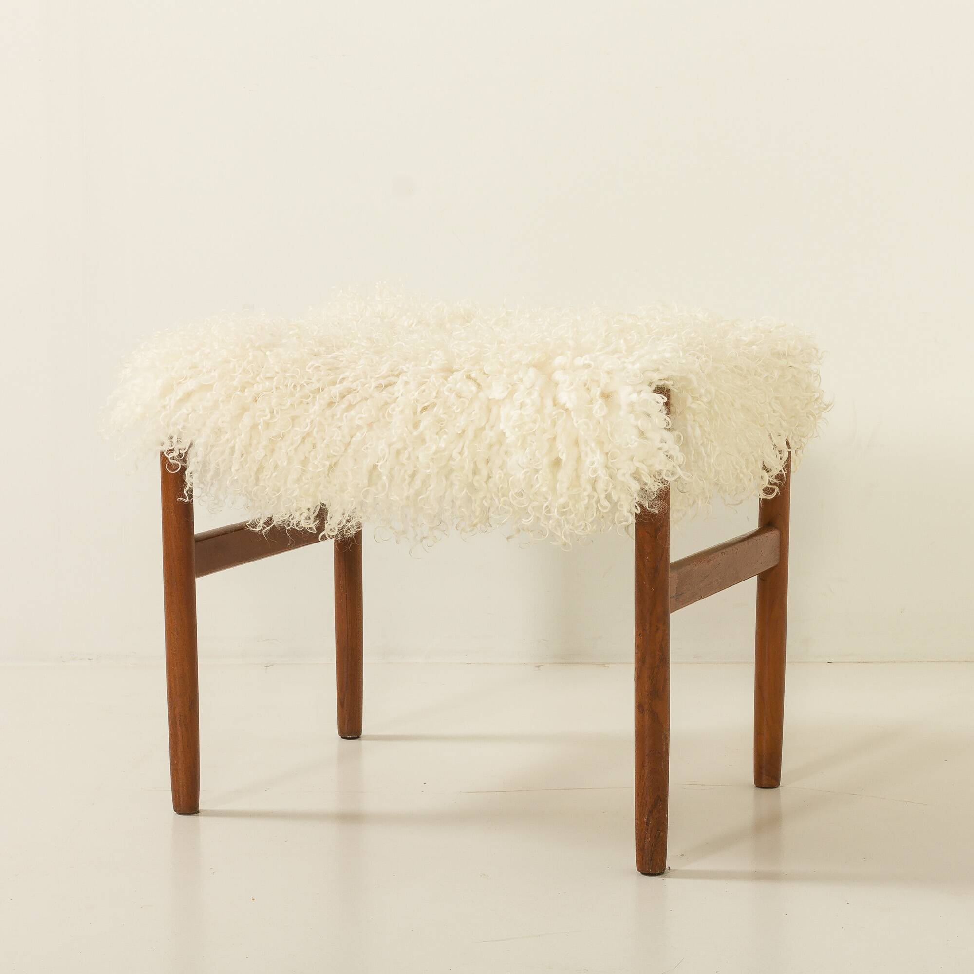 Pouf en teck danois des années 60 recouvert de peau de mouton à poils longs.