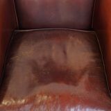 Comfortable, rugged cognac-colored sheepskin club armchair with a characteristic seat cushion