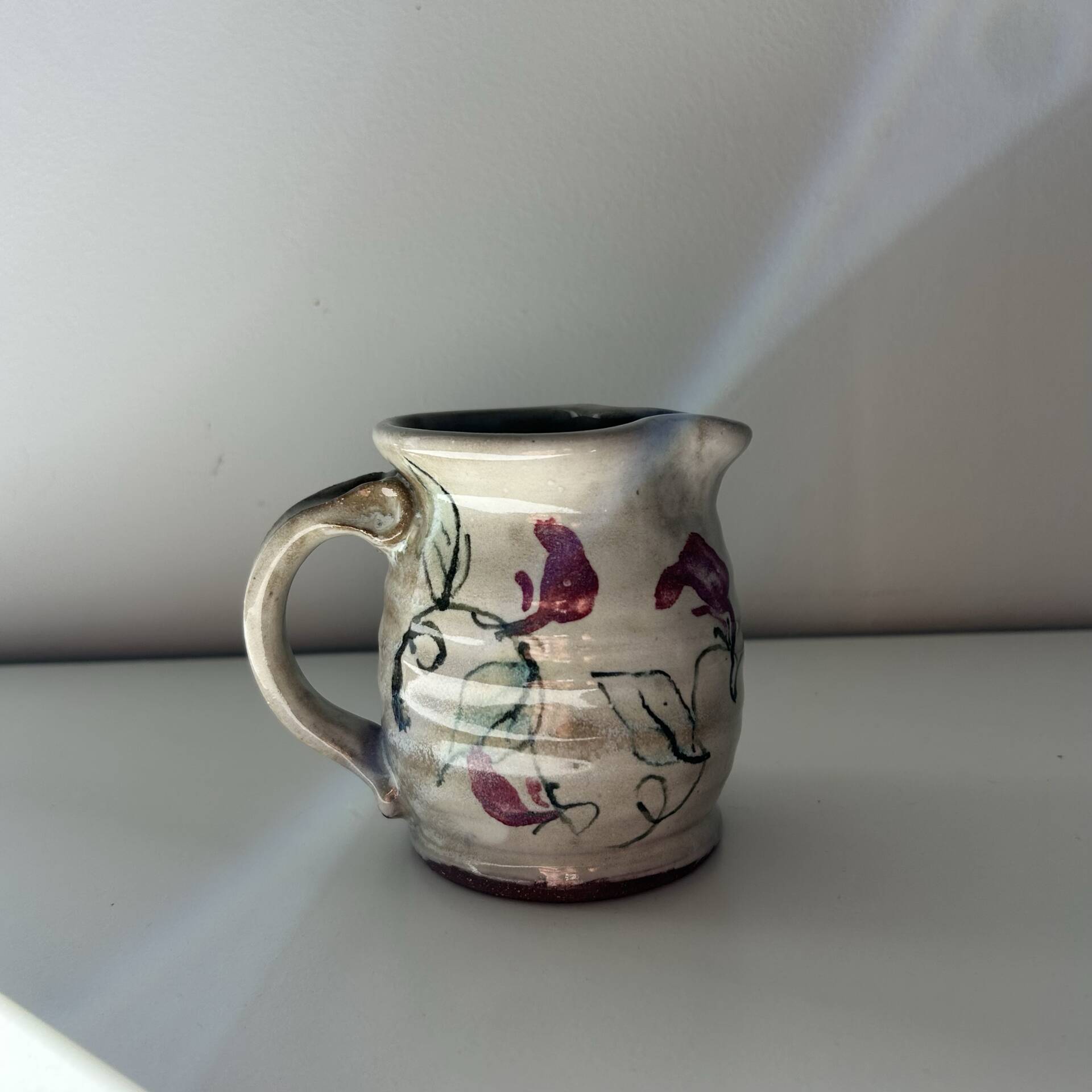Floral decorated pitcher signed