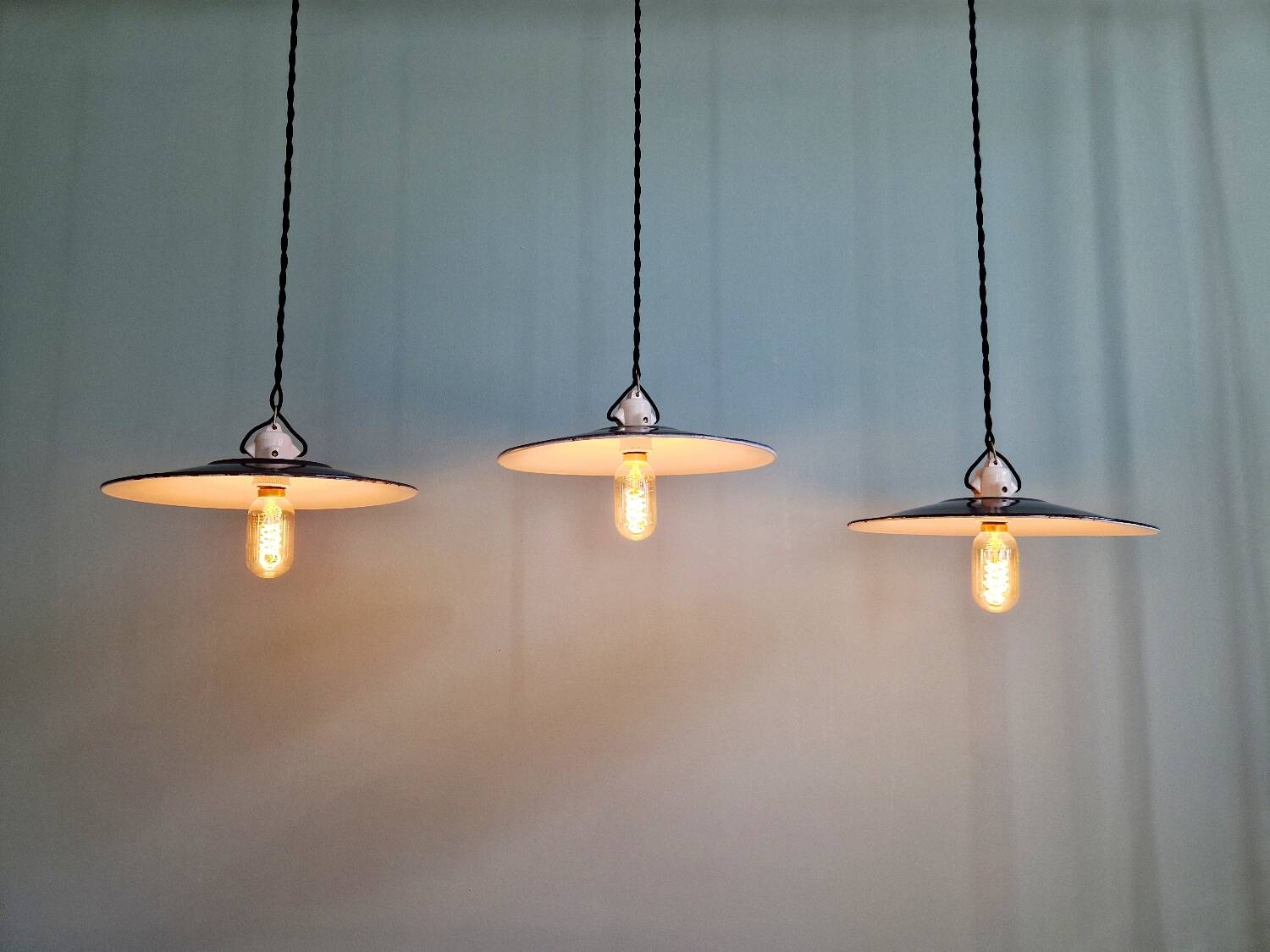 Three industrial suspensions in black enamelled sheet metal.