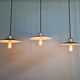 Three industrial suspensions in black enamelled sheet metal.