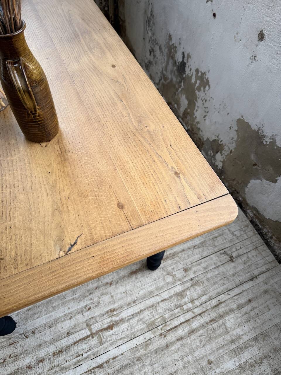 Oak farmhouse table with turned black legs.