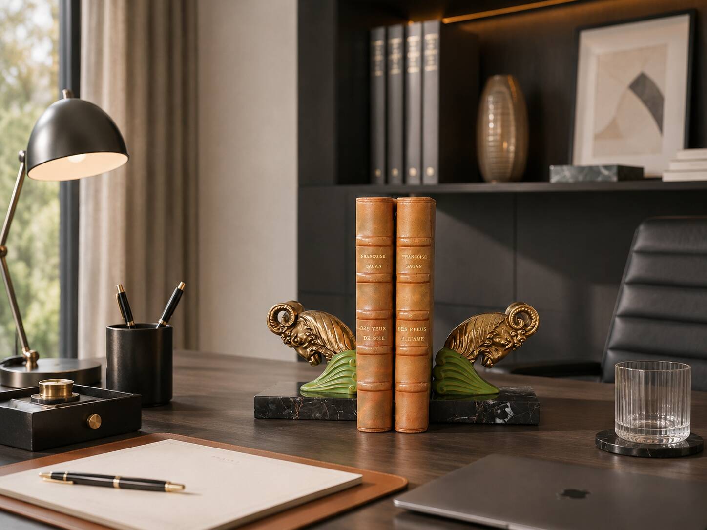 Art Deco pair of bookends with ram's heads, patinated metal and black marble.