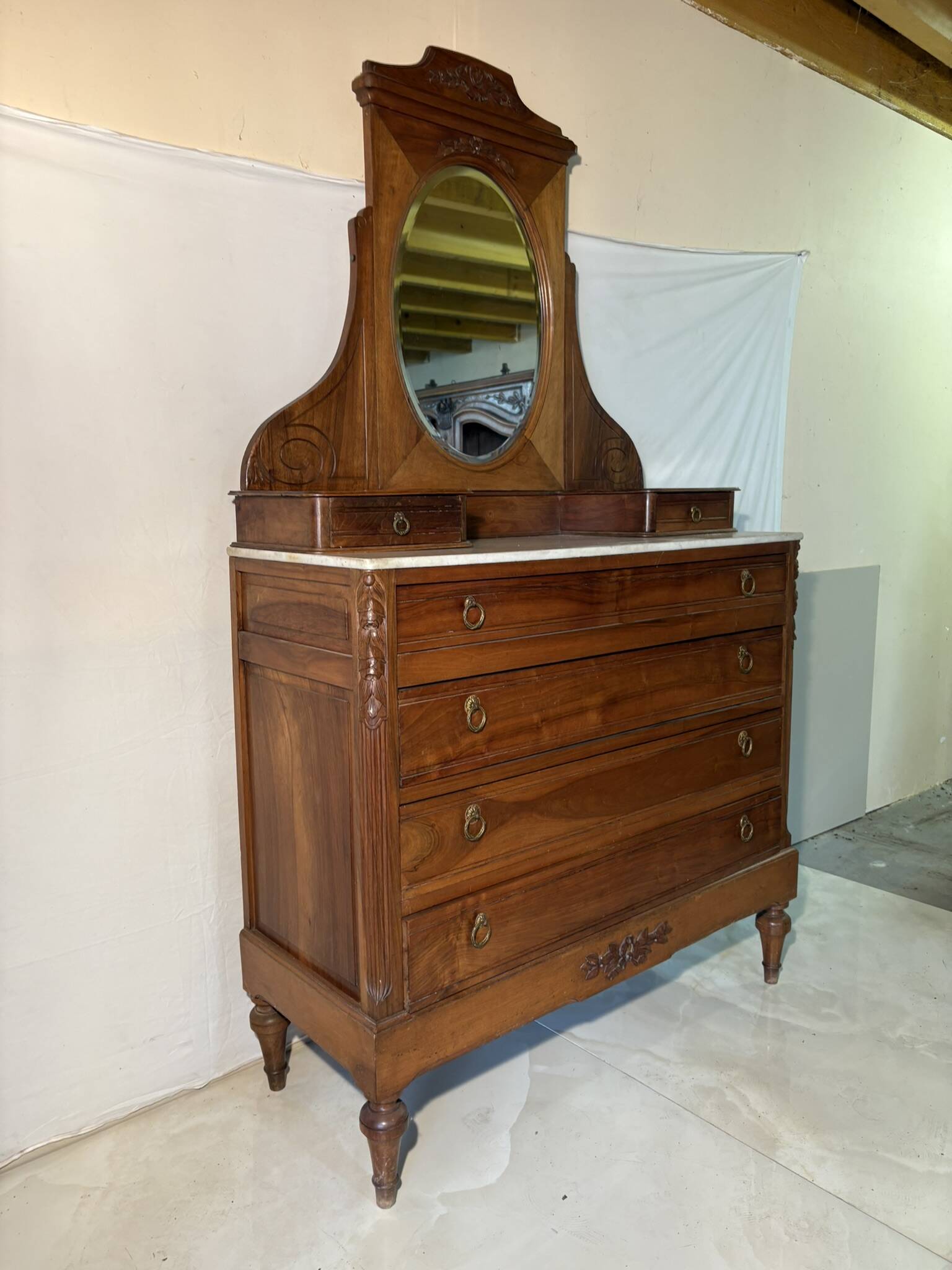 Antique carved wooden dressing table with marble and tilting oval mirror.