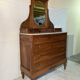Antique carved wooden dressing table with marble and tilting oval mirror.