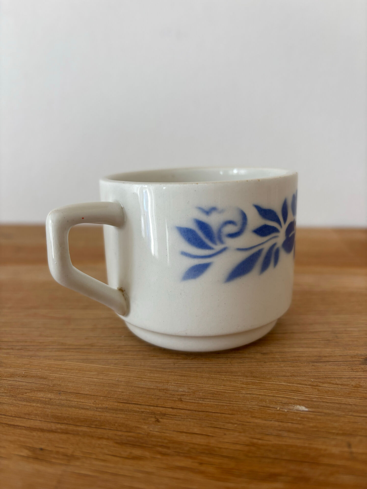 Set of 2 antique earthenware cups with blue floral pattern.