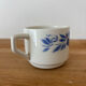 Set of 2 antique earthenware cups with blue floral pattern.